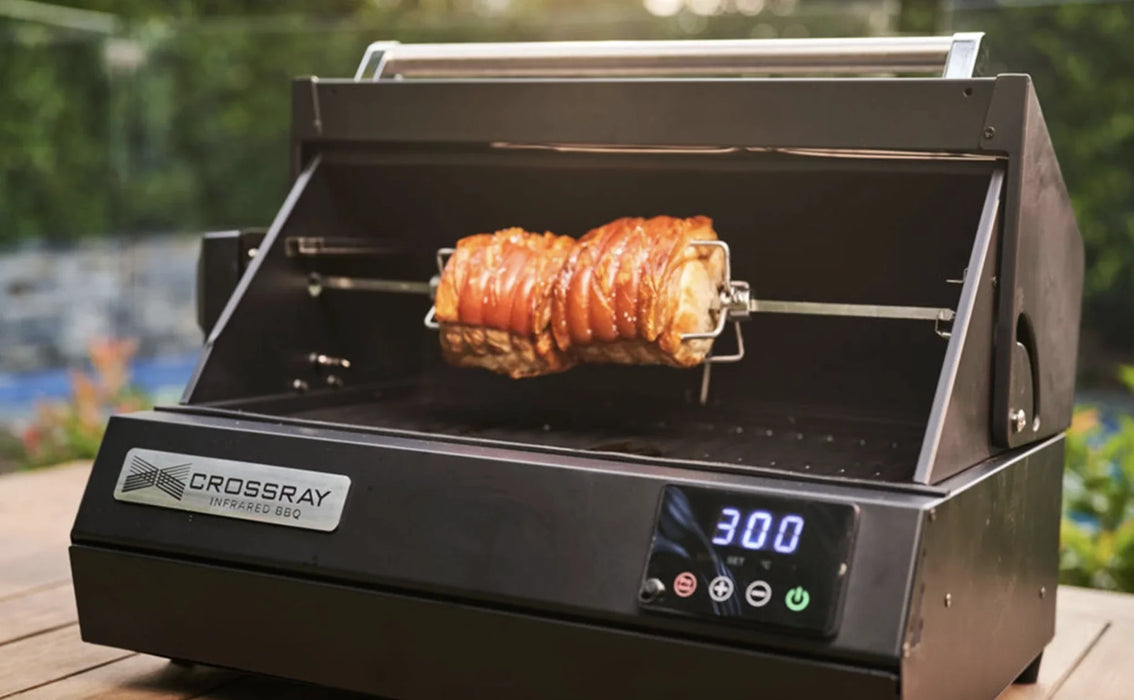 Electric BBQ rotisserie kit cooking pork roast outdoors, digital temperature display visible