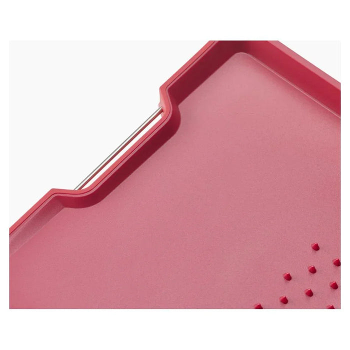 Red plastic cutting board with juice groove and textured non-slip surface