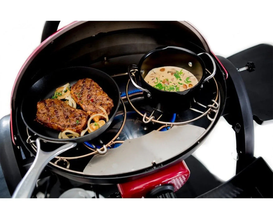 Portable gas grill with trivet kit cooking steak and sauce in outdoor cookware