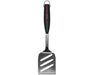 Stainless steel barbecue spatula with black handle and slotted blade on white background